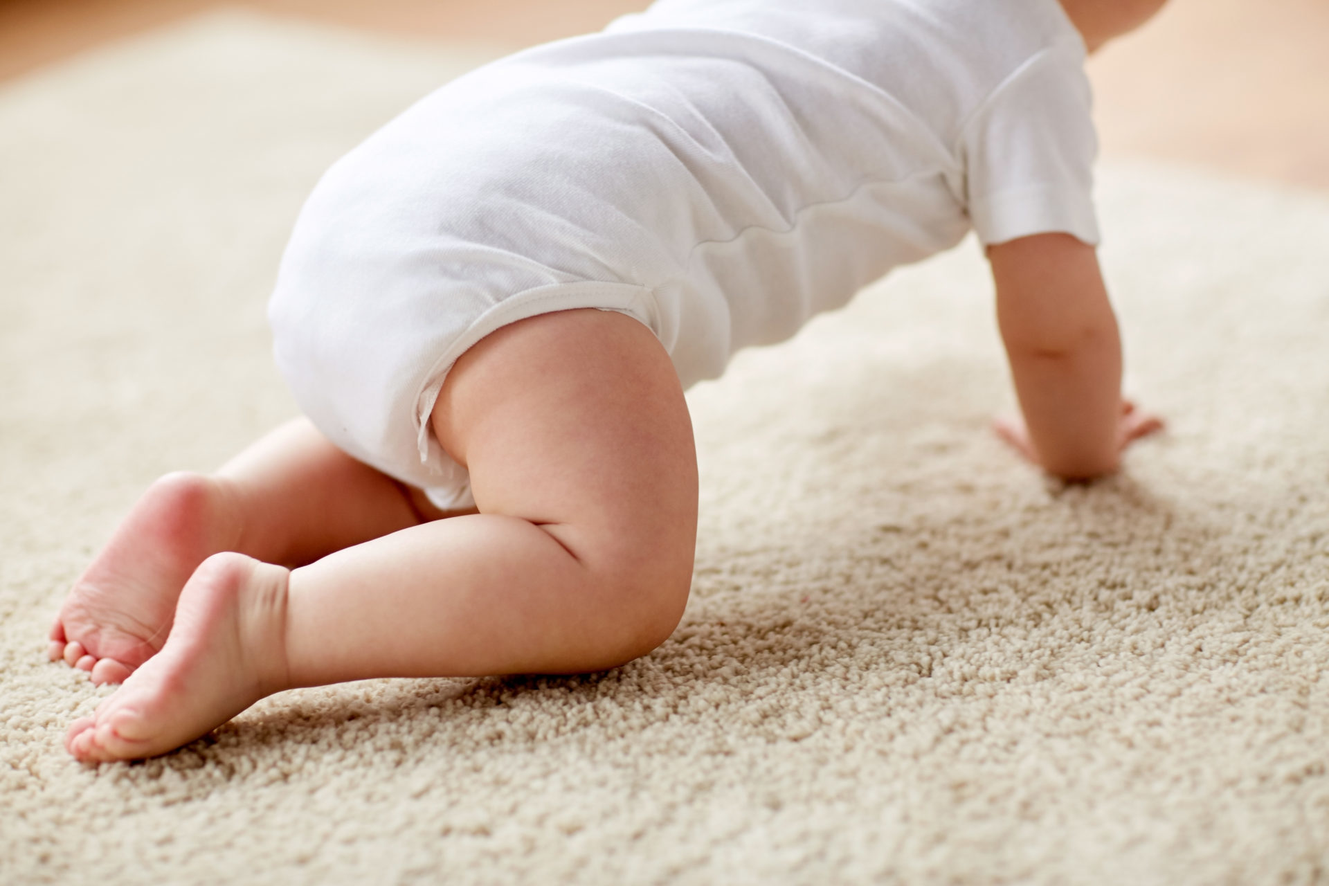 little baby in diaper crawling on floor at home childhood, babyhood and people concept - little baby boy or girl crawling on floor at home